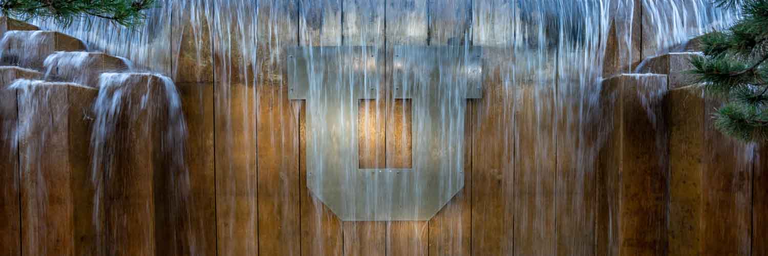 photo of waterfall feature with a metal U logo behind it